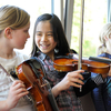 Drei Jugendliche üben Violine
